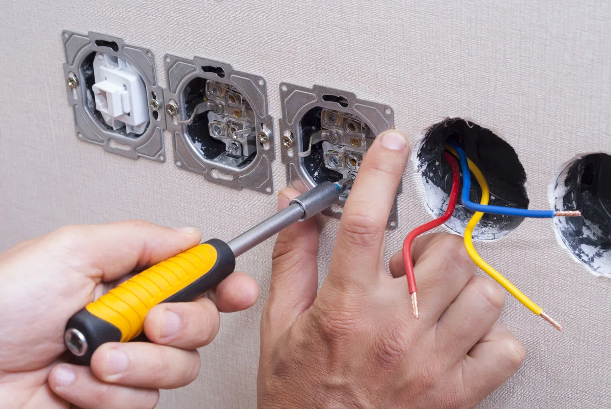 Rénovation électrique : travail sur câblage encastré dans un mur pendant rénovation